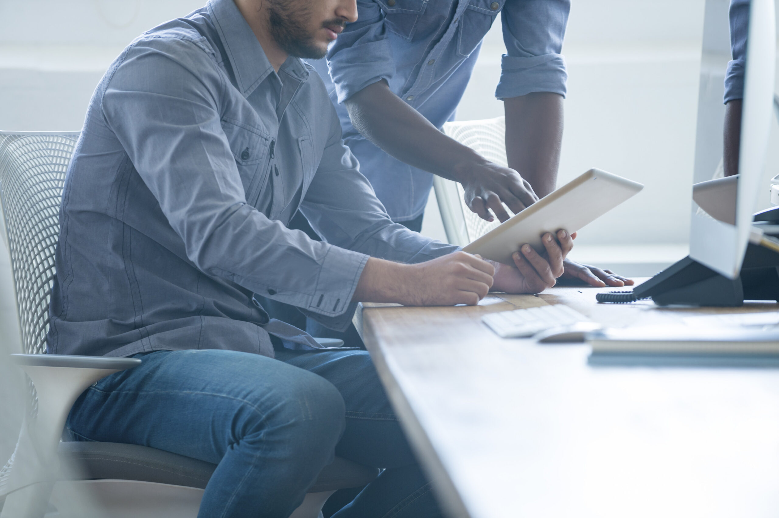 two people in office looking at a notebook